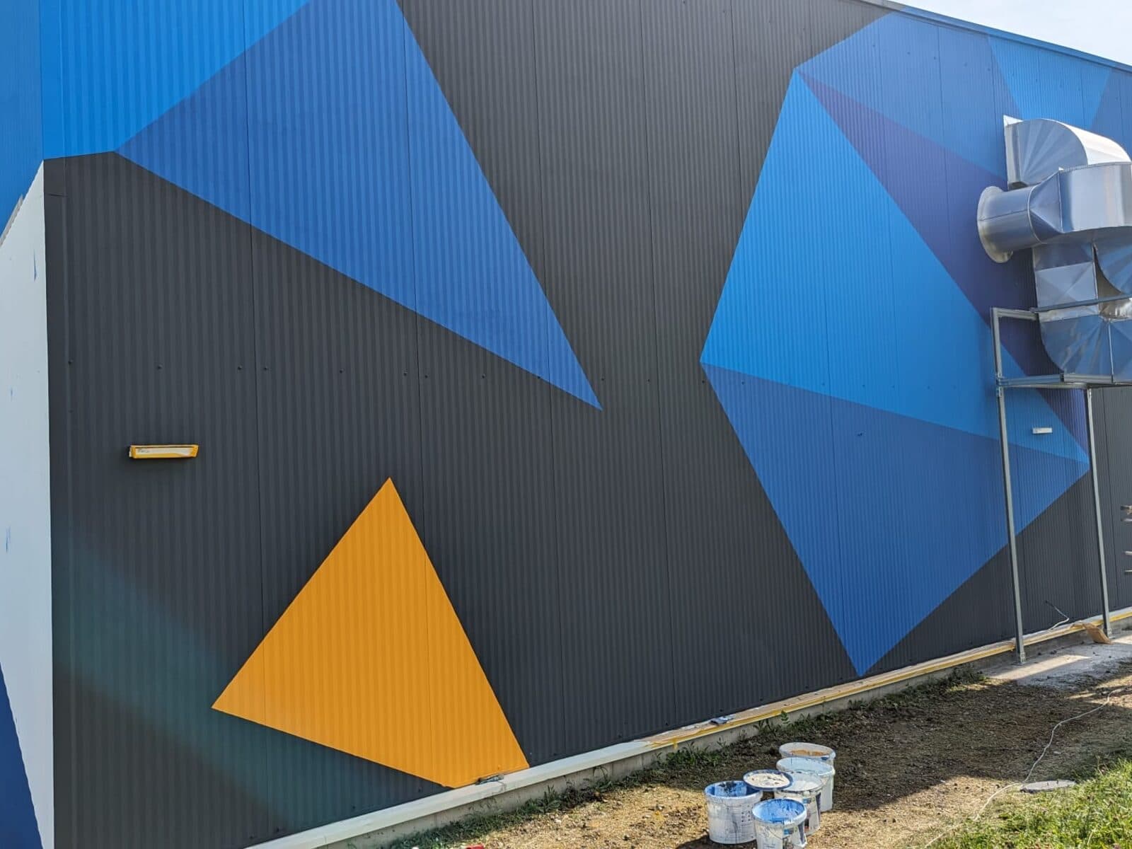 A Cyberjump trambulinpark bécsi csarnokának festett homlokzata, geometrikus mintával.